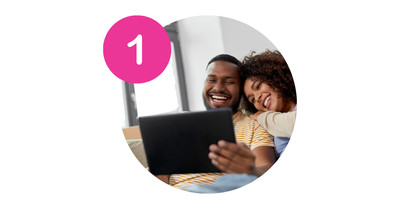 Two people sitting on a couch looking at a tablet to schedule appointment with chiropractor