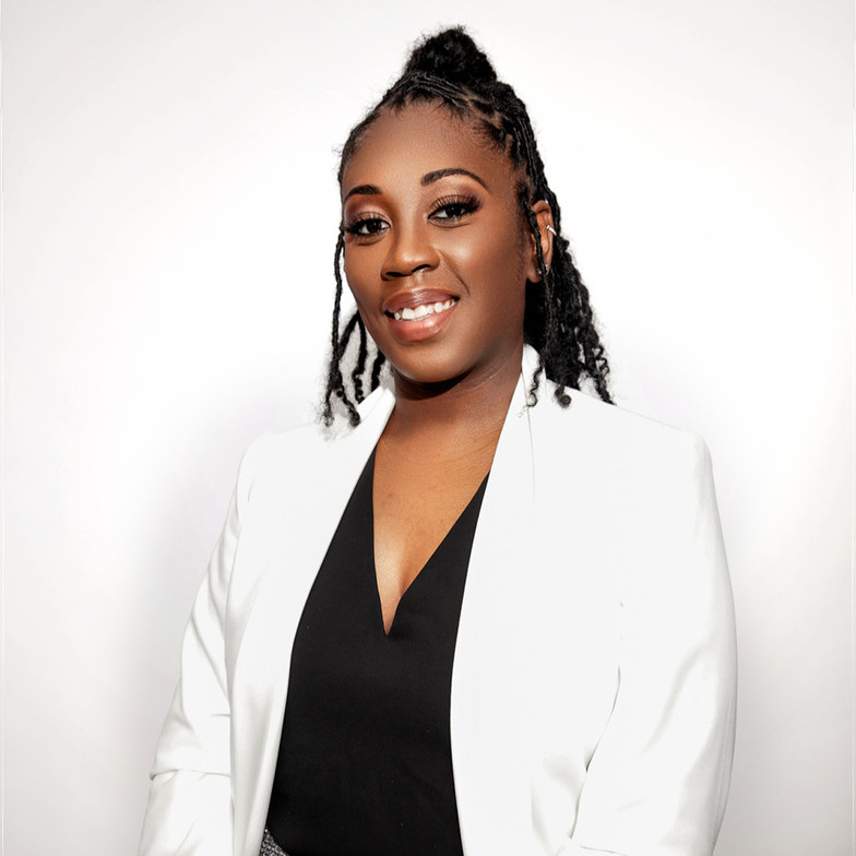 Dr. Magen Henry, a professional chiropractor, smiling confidently in a white blazer, representing her expertise in prenatal and pediatric chiropractic care.